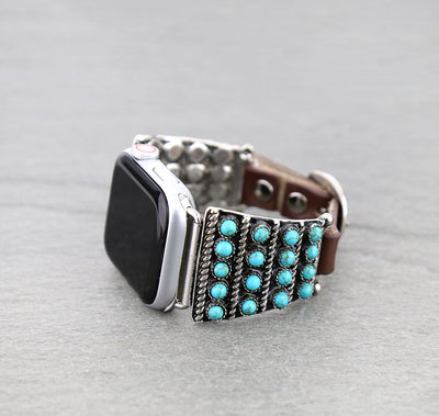 Silver watch band with turquoise stones on a gray background