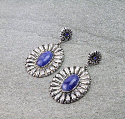 silver concho earrings with blue stones on a  gray background