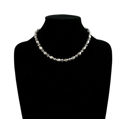 Pearl necklace on a black mannequin with a white background