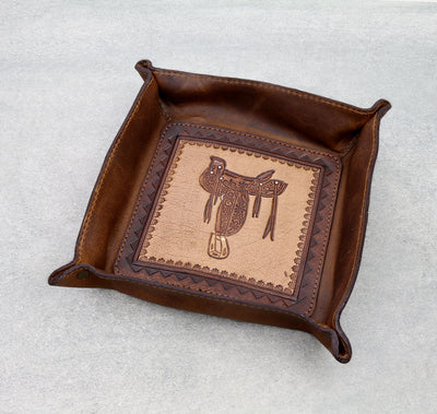 Brown leather tray with saddle design on a light gray background