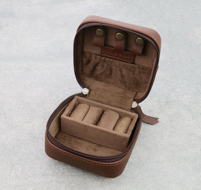 Brown jewelry case with velvet interior on a light gray background