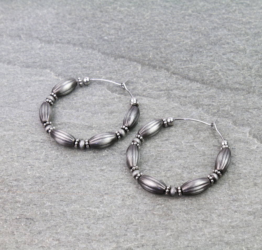 Pair of beaded hoop earrings on a gray background