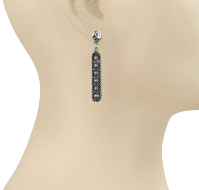 Silver earring on a mannequin ear with 'Blue Tortoise' branding.