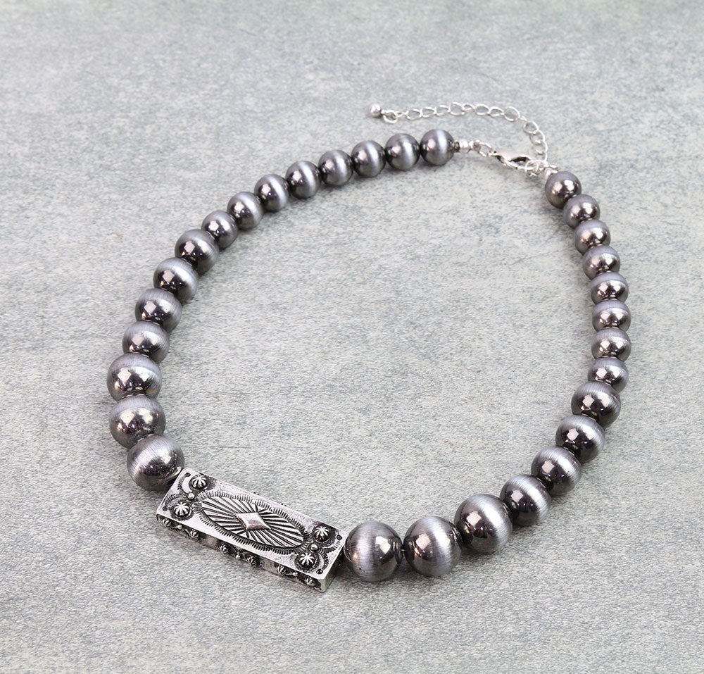 Necklace with gray beads and silver clasp on a light gray background