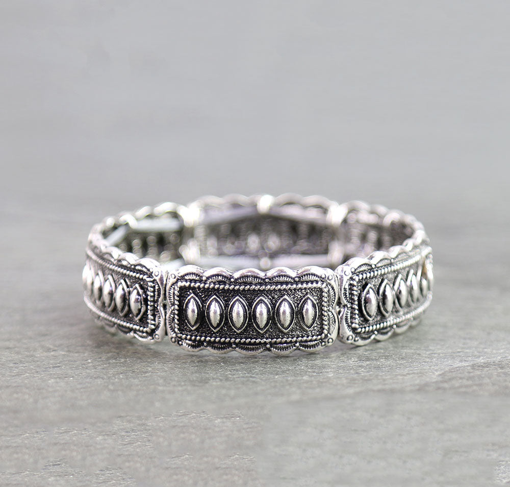 silver stretch bracelet on a gray surface
