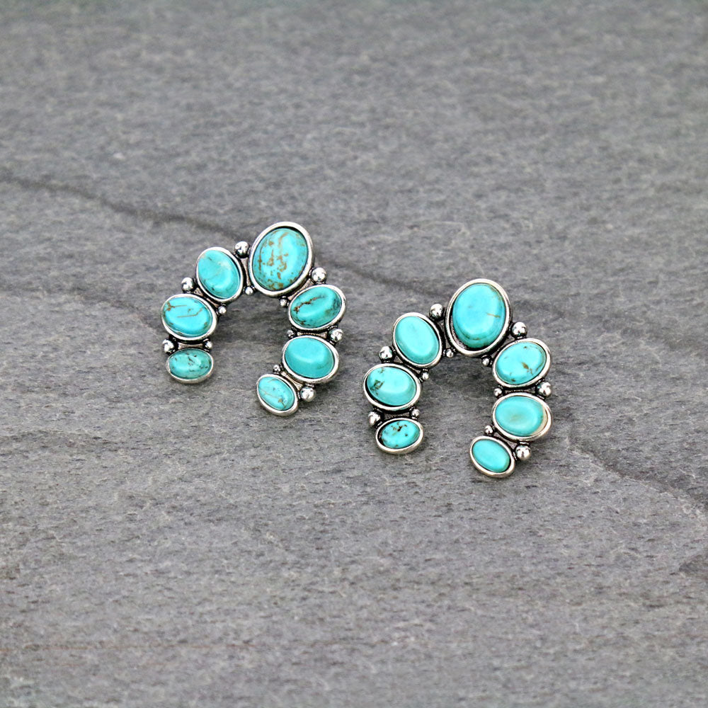 turquoise naja earrings on a gray background