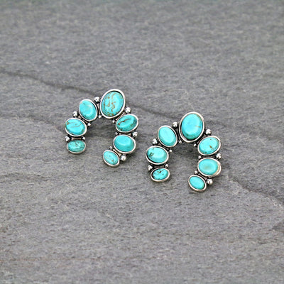 turquoise naja earrings on a gray background