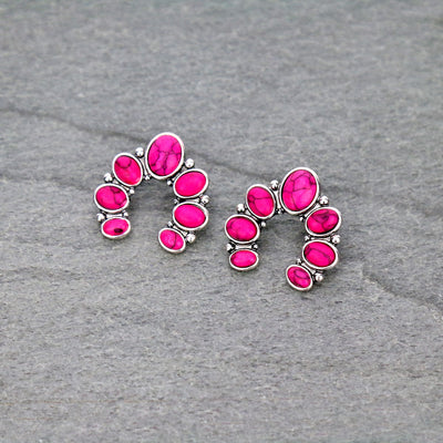 Pair of pink gemstone earrings on a gray surface