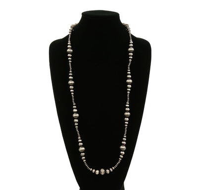 Long pearl necklace on a black mannequin against a white background