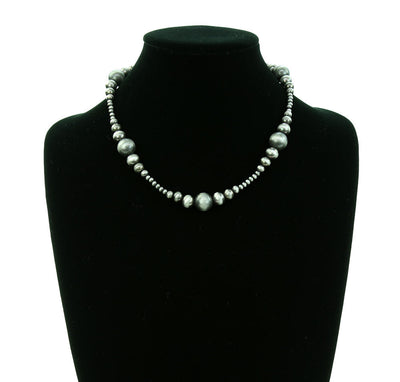 Pearl necklace on a black mannequin bust with a white background