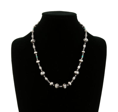 Stamped silver bead necklace on a black mannequin bust