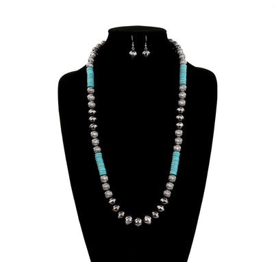 Jewelry set with turquoise and silver beads on a black stand, branded 'Blue Tortoise'.