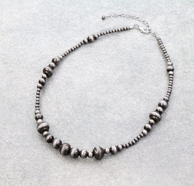 silver bead necklace on a gray background
