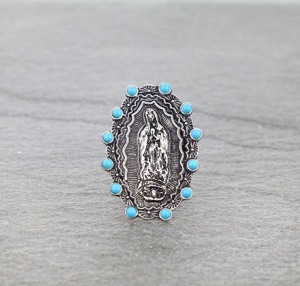 silver & turquoise lady of Guadalupe ring on a gray surface