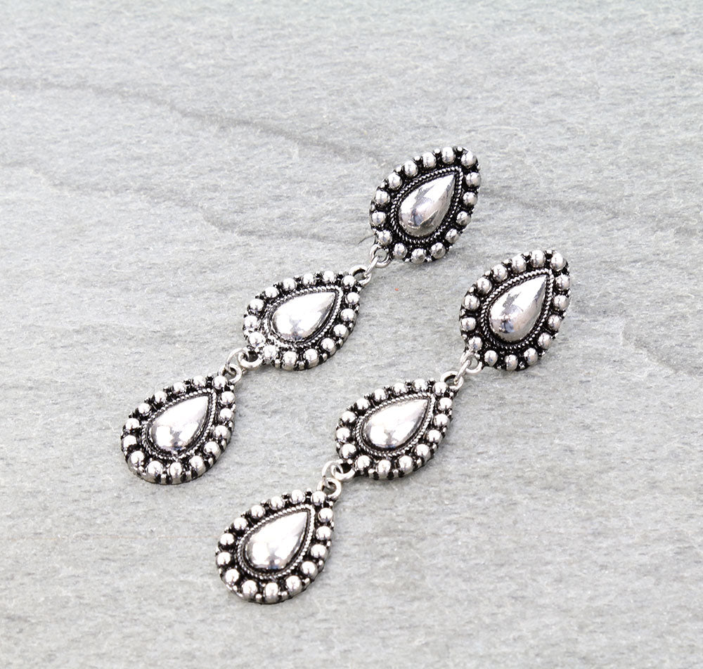 pair of silver teardrop dangle earrings on a gray background