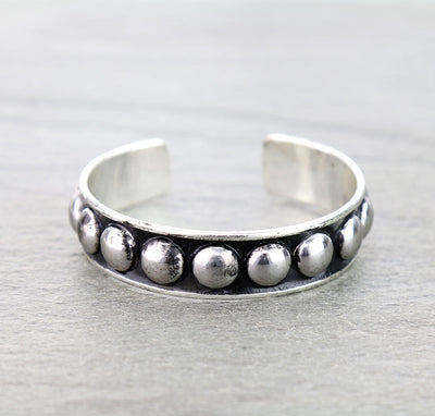Silver bracelet with bead detailing on a gray background