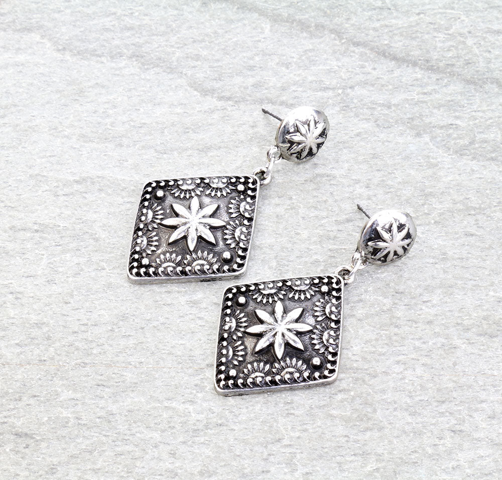 pair of silver concho earrings on a gray background