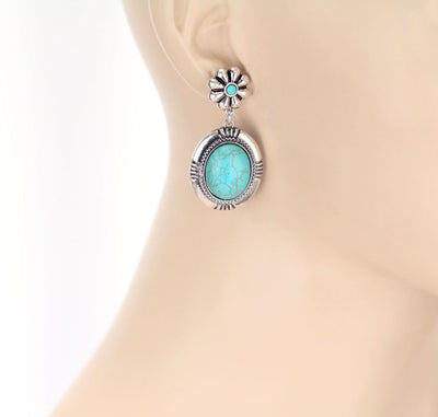 Turquoise earring on a mannequin ear for size