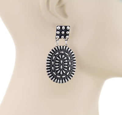 Decorative silver earring on a mannequin