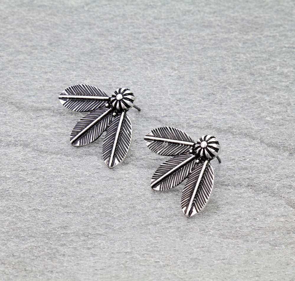 Pair of silver feather-shaped earrings on a gray background