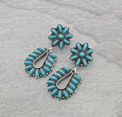 Turquoise floral earrings on a gray background