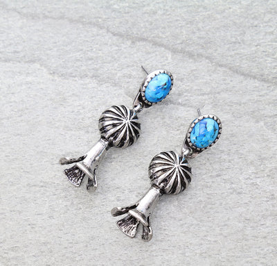 pair of turquoise dangle earrings on a gray background