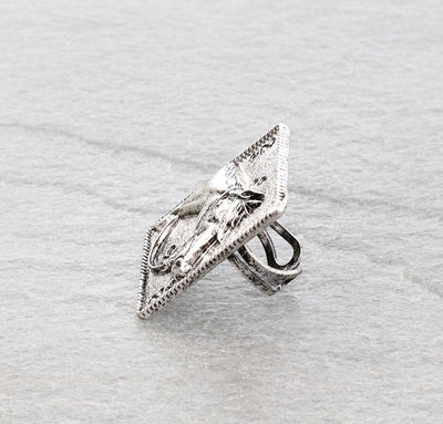 side view of horse card ring on a gray surface