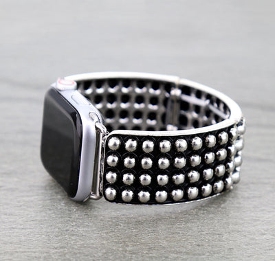 Silver studded band on a gray background