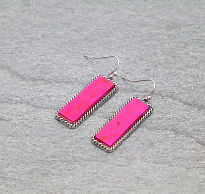 Pink rectangular earrings with silver accents on a gray background