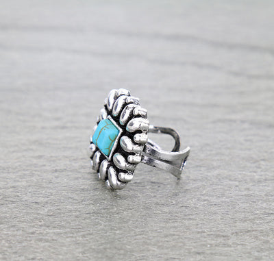 Silver ring with turquoise stone on a gray background