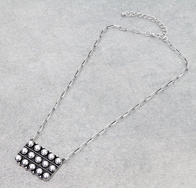 silver necklace on gray background