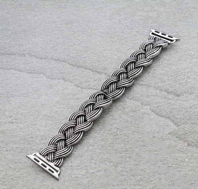 Silver braided watch strap on a gray background
