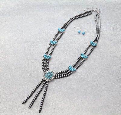 turquoise cluster multi strand silver bead necklace & turquoise bead earrings on a gray background