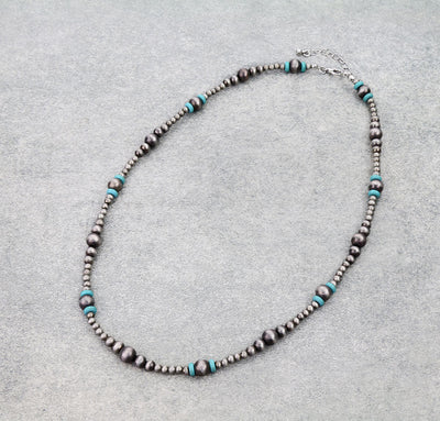 Necklace with silver and turquoise beads on a gray background