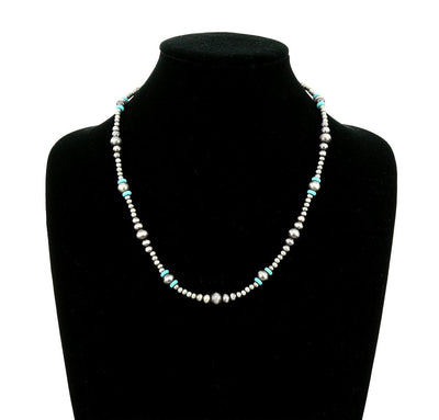 Necklace with pearls and turquoise beads on a black mannequin bust.