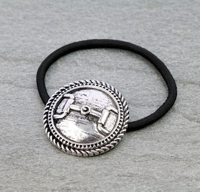 Black hair elastic with silver decorative accent on a gray background