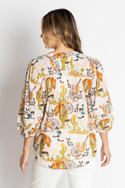 model wearing a white Western print top