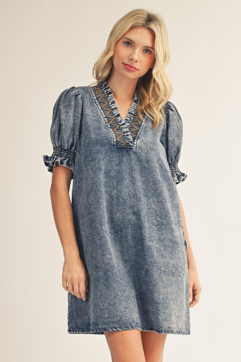 model wearing denim dress with tan background