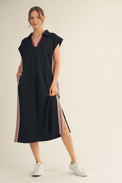 model wearing a black dress with stripes along the sides & neckline.