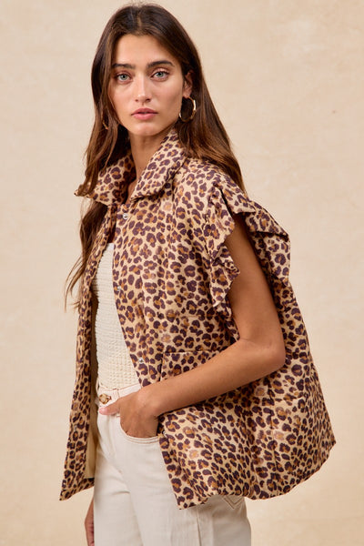 Woman wearing a leopard print vest over a white top and pants on a beige background