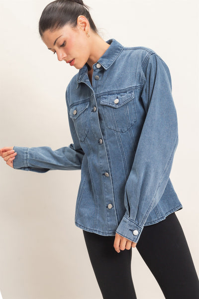 model wearing button down denim jacket and black pants with a light background