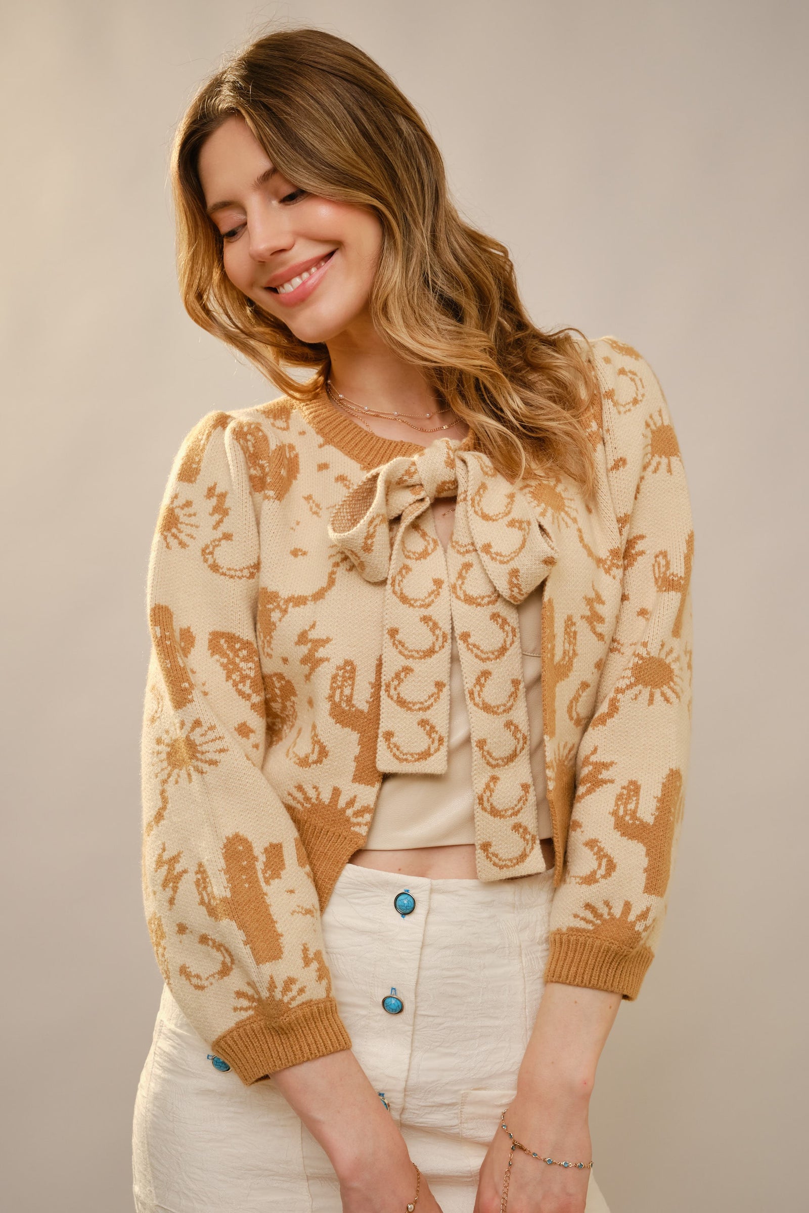 Woman wearing a patterned cardigan with a neutral background