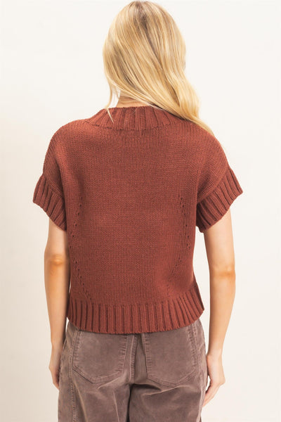 back of model wearing a short sleeve star sweater with charcoal pants
