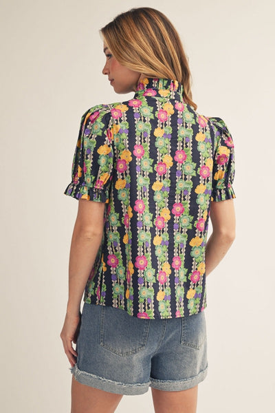 model wearing button down floral top & cuffed denim shorts