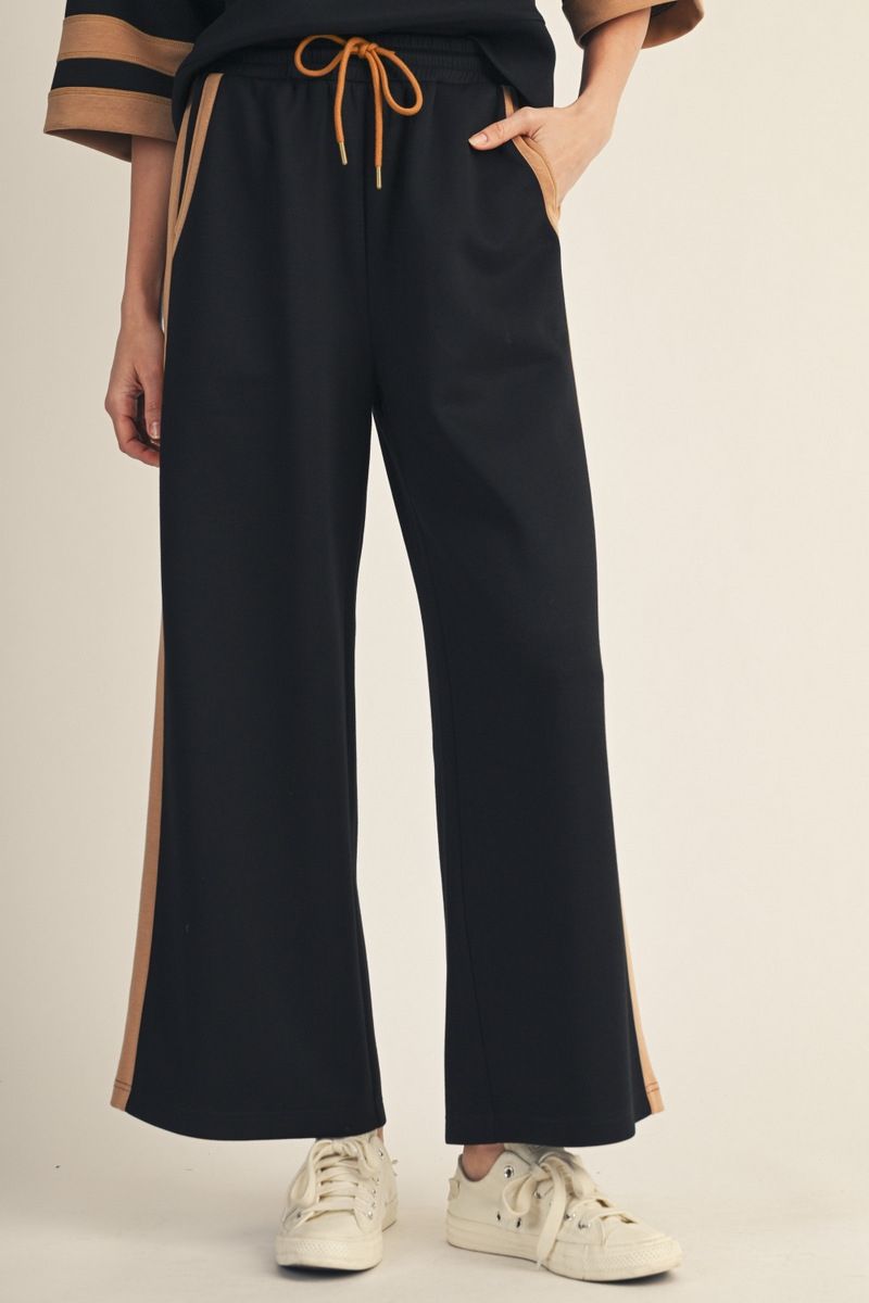 person wearing black pants with drawstring and pockets