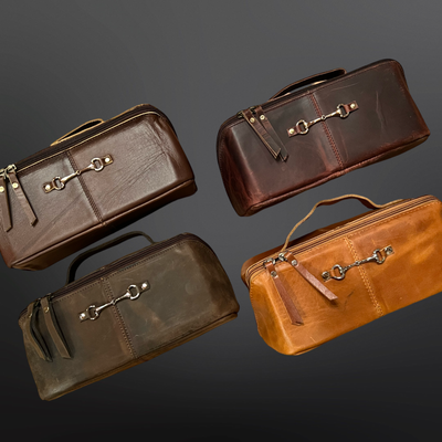 Four brown leather bags with gold hardware on a dark gray background