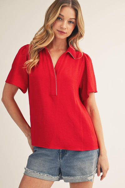 model wearing a red v neck blouse with cuffed jean shorts