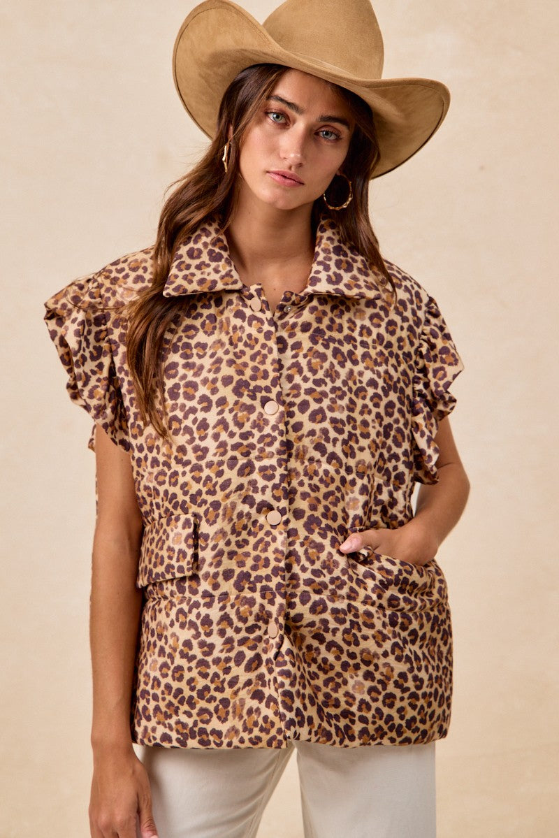 Woman wearing a leopard print top and beige hat against a beige background