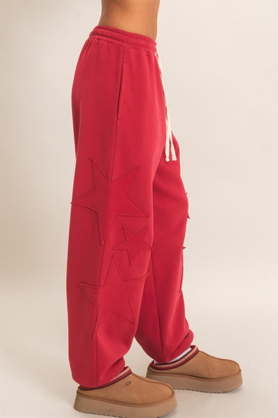 side view of model wearing red start patch joggers and ugg shoes