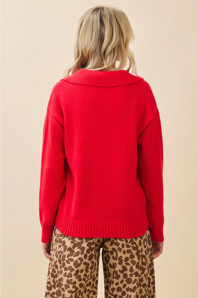 Person wearing a red sweater and leopard print pants on a beige background